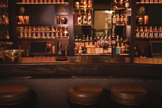 Warm, retro interior of Your Bar with vintage bottles and a polished wooden bar